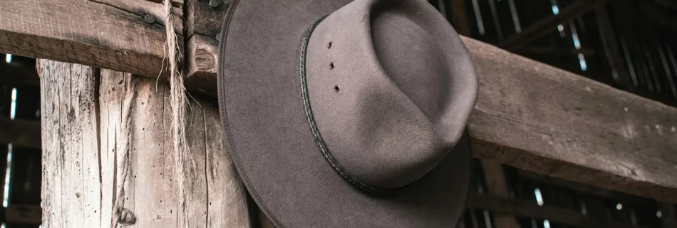 a hat is hanging on a wooden pole