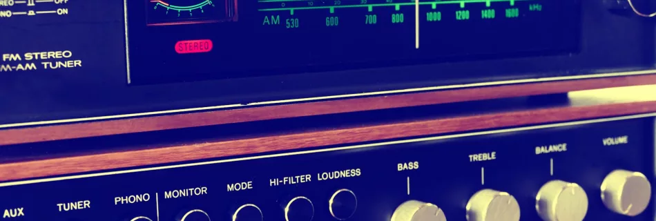 A retro FM-AM stereo tuner with knobs and wooden accents, embodying vintage audio equipment.