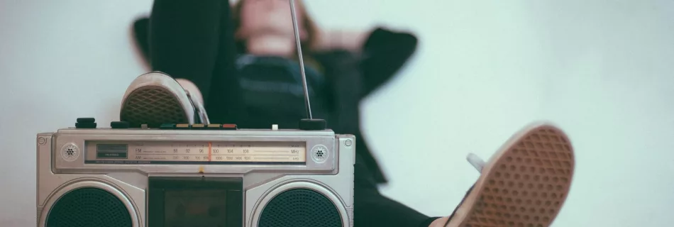 woman laying on bed near gray radio