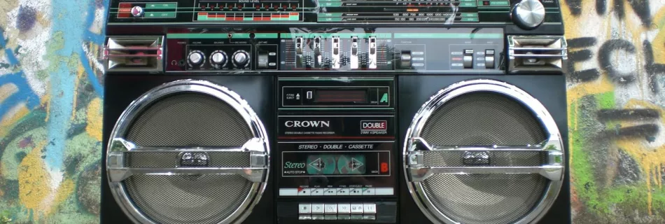 Classic vintage boombox placed in front of a vibrant graffiti-covered wall. Perfect for retro lovers.